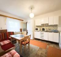 Eine Küche in einem Einfamilienhaus mit hellen Möbeln, einem Esstisch und einer Sitzecke.