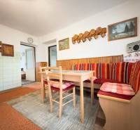 Esszimmer eines Einfamilienhauses mit Eckbank, Holzdekor und dekorativen Bildern an der Wand.