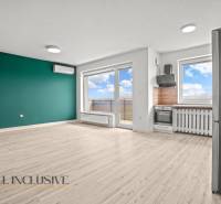 Wohnzimmer mit Küchenzeile in einer 2-Zimmer-Wohnung und einem Bodenbelag in Holzoptik.