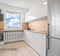 Weiße Küche in einer 2-Zimmer-Wohnung mit Holzboden und Blick aus dem Fenster.