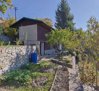 Gärten in Bratislava - Devín an der Spätná cesta, Steinmauer, Bäume und Grün.