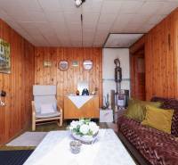 Ein Interieur mit holzgetäfelten Wänden, Kacheln und Retro-Möbeln in den Gärten.