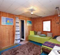 Holzverkleidung an den Wänden, Sofas mit Kissen und Teppich im Inneren der Gartenhütte.