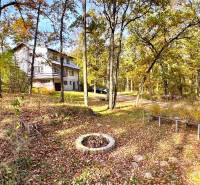 Eine Hütte im Wald auf der Gazárka-Straße in Šaštín-Stráže, umgeben von herbstlichen Bäumen und Laub.
