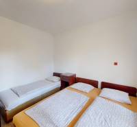 Schlafzimmer in einer Hütte mit einem Einzelbett und zwei zusammengestellten Betten, Raum zum Entspannen.