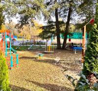 Ein Kinderspielplatz umgeben von Bäumen, Schaukeln und Klettergerüsten in Gazárka in Šaštín-Stráže.