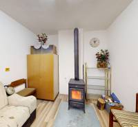 Ein Zimmer in einer Hütte mit einem Ofen, Sofas und Dekorationen, der Boden mit Holzdekor.