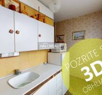 Küche in einer 3-Zimmer-Wohnung mit weißen Schränken und Bildern an den Wänden.