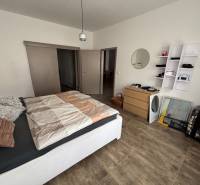 Schlafzimmer in einer 2-Zimmer-Wohnung mit Holzboden, Bett und Stauraum.