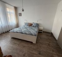 Schlafzimmer in einer 2-Zimmer-Wohnung mit einem großen Bett und einem Fliesenboden.