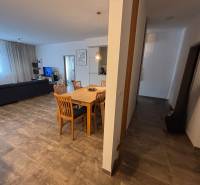 Esstisch mit Holzstühlen in einer 2-Zimmer-Wohnung. Dazu gehören ein Sofa und ein Fernseher.