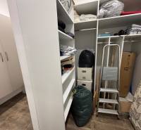 Úložný Raum in einer 2-Zimmer-Wohnung mit Regalen, Treppen und Kisten.