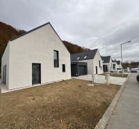 Einfamilienhaus in der Straße Pod Drieňovou in Kamenica nad Cirochou, Reihenhausbebauung mit Autos.