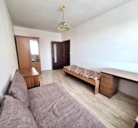 Ein Zimmer in einer 3-Zimmer-Wohnung mit einem Holzboden, einem Bett und einem Schrank.