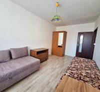 Wohnzimmer in einer 3-Zimmer-Wohnung mit Holzboden und einfacher Einrichtung.