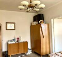 Ein Zimmer in einer 3-Zimmer-Wohnung mit Holzmöbeln und einem dekorativen Kronleuchter.