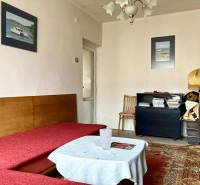 Wohnzimmer in einer 3-Zimmer-Wohnung mit Sofa, Teppich und dekorativen Bildern an der Wand.