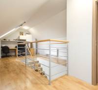 Dachgeschoss-Arbeitszimmer in einer 4-Zimmer-Wohnung mit Holzboden-Dekor und Geländer.