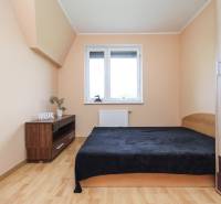 Schlafzimmer in einer 4-Zimmer-Wohnung mit Bett und Boden in Holzoptik.