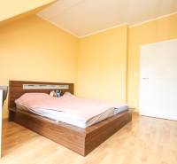 Schlafzimmer in einer 4-Zimmer-Wohnung mit Bett und Boden in Holzoptik.