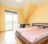 Schlafzimmer in einer 4-Zimmer-Wohnung mit Bett, Schrank und Boden in Holzoptik.