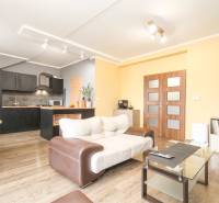 Wohnzimmer in einer 4-Zimmer-Wohnung mit Küche und Holzboden.