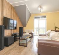 Wohnzimmer mit Sofa, Fernseher und Holzboden in einer 4-Zimmer-Wohnung.