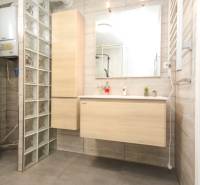 Badezimmer mit Spiegel und Waschbecken in einer 4-Zimmer-Wohnung, Dekor der Glaswand.