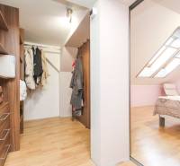 Ein Kleiderschrank und ein Schlafzimmer in einer 4-Zimmer-Wohnung mit einem Boden in Holzdekor.