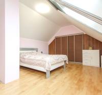 Schlafzimmer in einer 4-Zimmer-Wohnung mit Holzboden und Dachfenster.