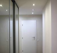 Flur mit eingebautem Spiegelschrank und Bodenbelag in Holzoptik in einer 3-Zimmer-Wohnung.