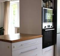 Küche in einer 3-Zimmer-Wohnung, dunkler Schrank mit eingebautem Ofen, daneben ein Kühlschrank.