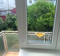 Blick aus einer 3-Zimmer-Wohnung mit Fenstern und Balkon in einen grünen Innenhof.