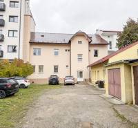 Das Gebäude in der Bratislavská Straße in Žilina, umgeben von Autos und Garagen, geeignet für Büros.