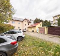 Parkplatz bei den Büros in der Bratislavská Straße in Žilina, Autos und Garagen im Hintergrund.