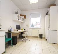 Büro mit Fliesen, Raum mit Computer, Möbeln und Kaffeemaschine.