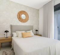 Schlafzimmer in einer Ferienwohnung, Bett, Nachttische, großes Fenster.