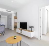 Ferienwohnung mit offenem Wohnzimmer, Esstisch und Holzboden.