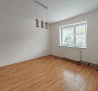 Ein Zimmer in einem Einfamilienhaus mit einem Holzboden und einem großen Fenster.