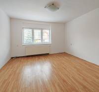 Ein Zimmer in einem Einfamilienhaus mit einem Holzboden und einem großen Fenster.