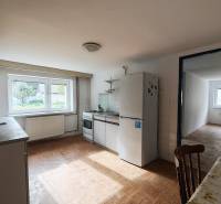 Eine Küche in einem Einfamilienhaus mit einem Boden in Holzoptik, ausgestattet mit Geräten und einem Esstisch.