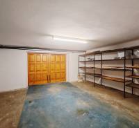 Garage in einem Einfamilienhaus mit Holztüren und Regalen.