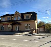 Ein Einfamilienhaus in Bolešov mit Dachgeschoss, großen Fenstern und einem Geschäftsraum im Erdgeschoss.