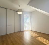 Innenraum eines Gebäudes mit Holzboden, Einbauschrank und Fenster mit Rollladen.