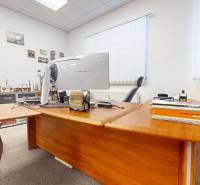 Büroflächen mit einem Holztisch, einem Computer und Dekorationsgegenständen an den Wänden.