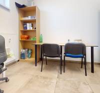 Büroräume mit Regal, Stühlen und Schreibtischen mit Holzdekorboden.