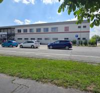 Gewerbeflächen in der Strojárenská-Straße in Trnava, mit Parkmöglichkeiten und Radfahrer.
