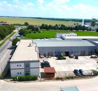 Gewerbeflächen in der Strojárenská-Straße in Trnava mit angrenzendem Parkplatz und Grünflächen in der Umgebung.