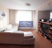 Wohnzimmer mit weißem Sofa und Fernseher, Holzboden, 2-Zimmer-Wohnung.