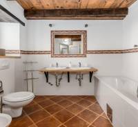 Badezimmer in der Villa mit weißen Wänden, Badewanne, Waschbecken und Boden mit Holzdekor.